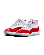 Plugmarket Air Jordan 11 Retro Cherry sneakers with white mesh uppers and patent leather red overlays.